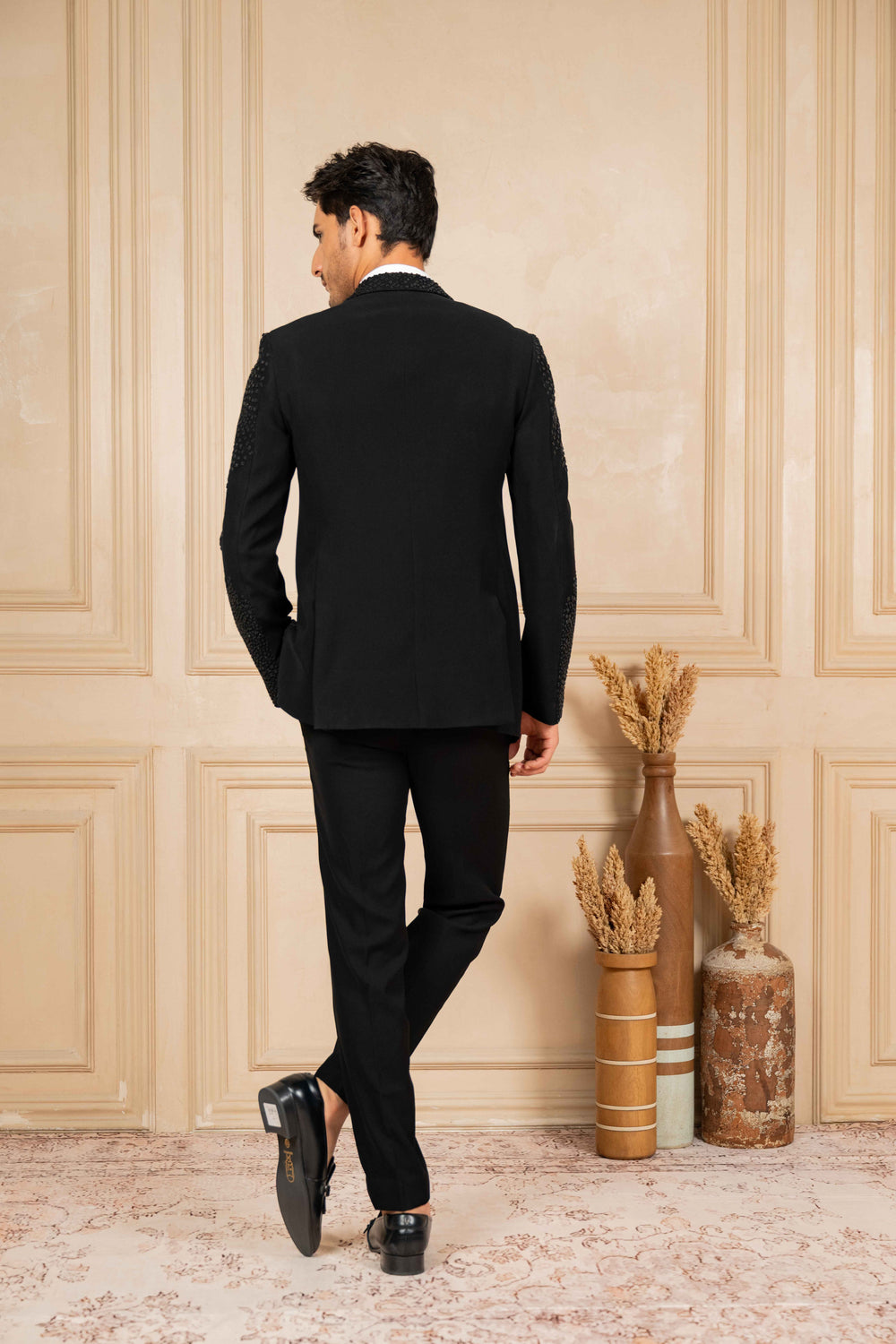 a black tuxedo with peak lapel  and pearl embroidery